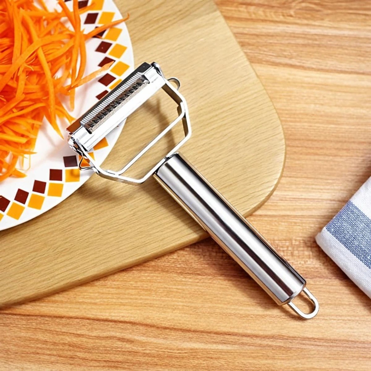 ANGEER dual-blade julienne peeler beside freshly julienned carrots on a wooden preparation board